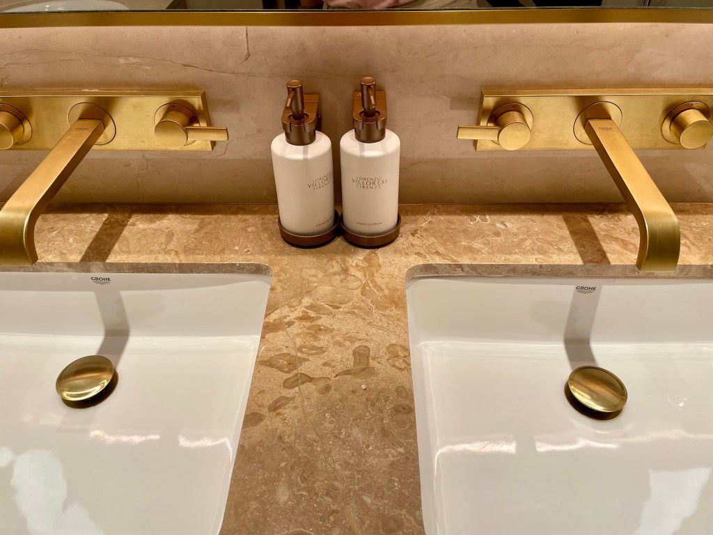 Elegant double vanity bathroom sink setup at Solaire Resort North, with gold fixtures and premium toiletries on a marble countertop.