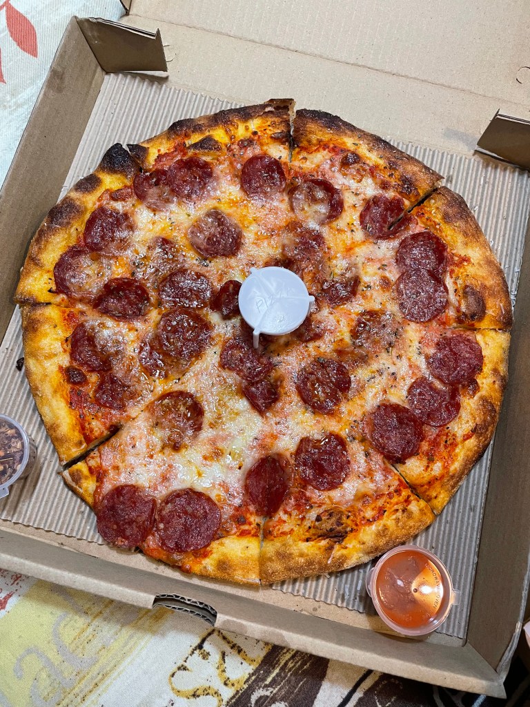 Close-up of Jabroni’s The Roni Pizza, featuring pepperoni slices on a thin-crust, New York-style pizza with charred edges and mozzarella cheese.
